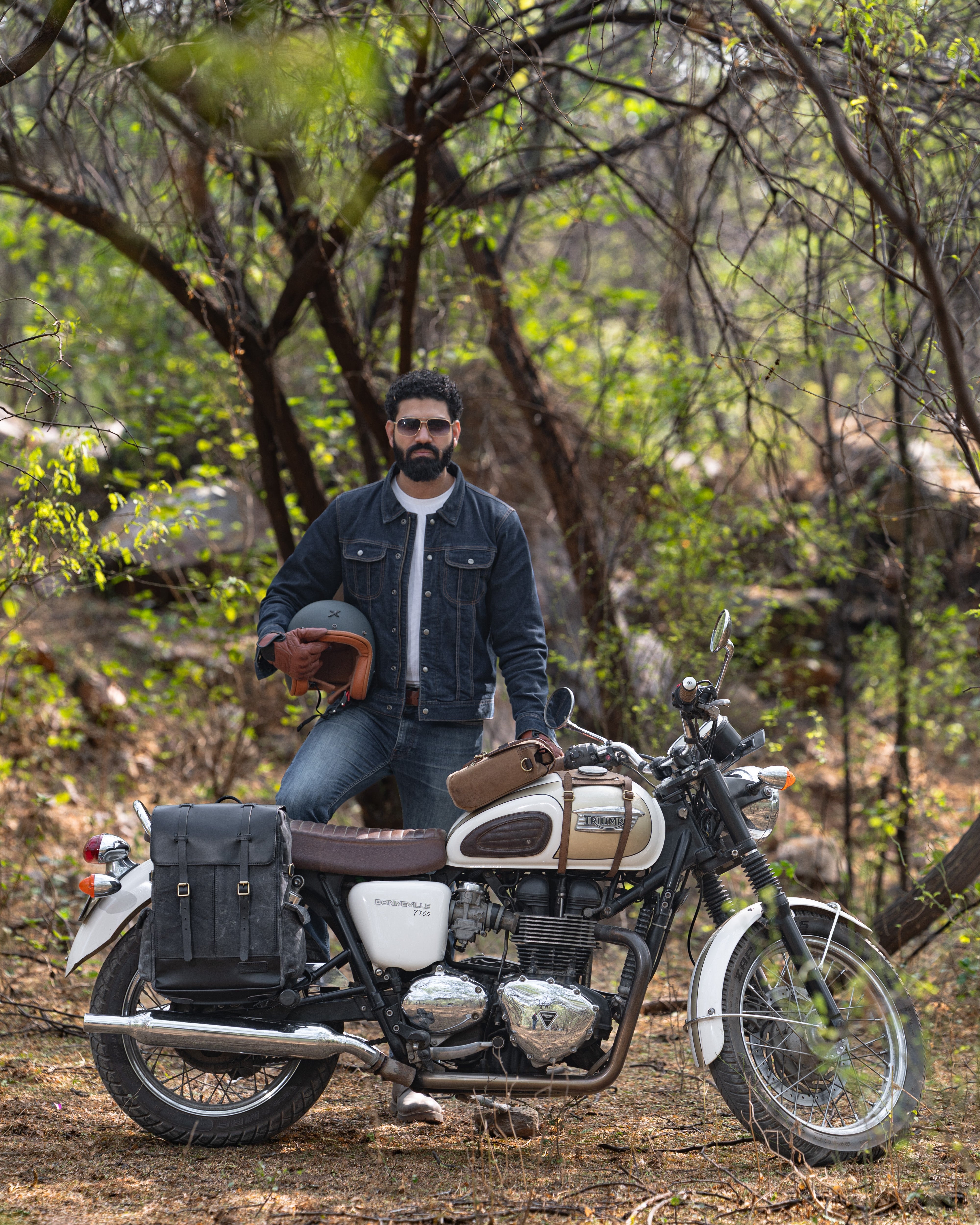 Man sitting on a motorcycle in a forest setting