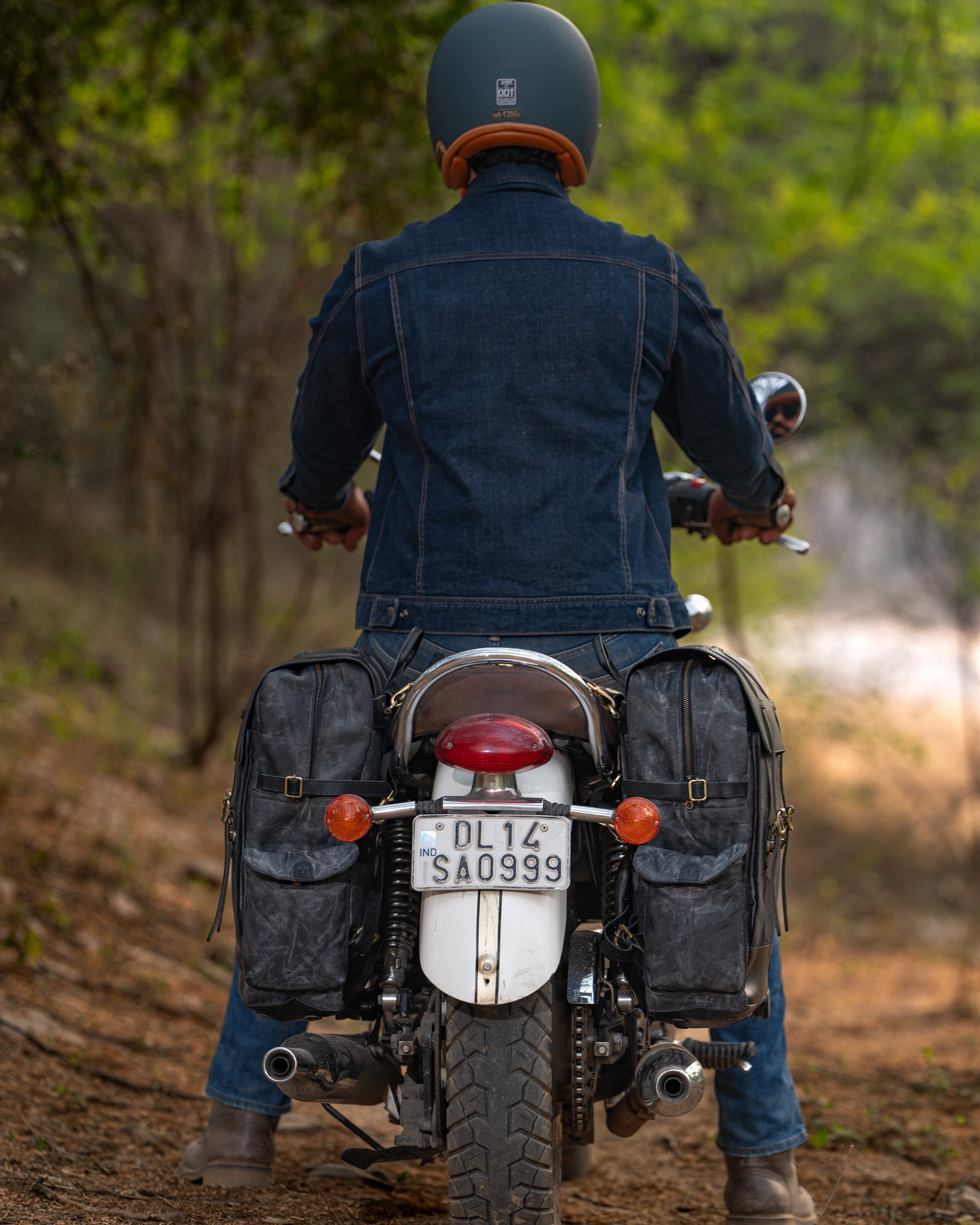 Person riding a motorcycle on a dirt road with a helmet on