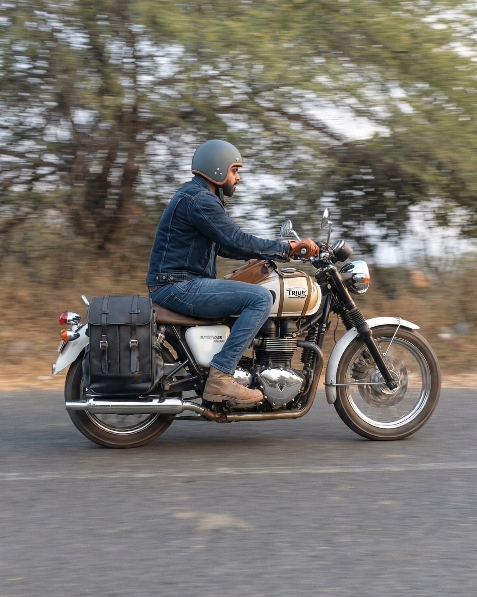 Man riding a motorcycle on a road with trees in the background