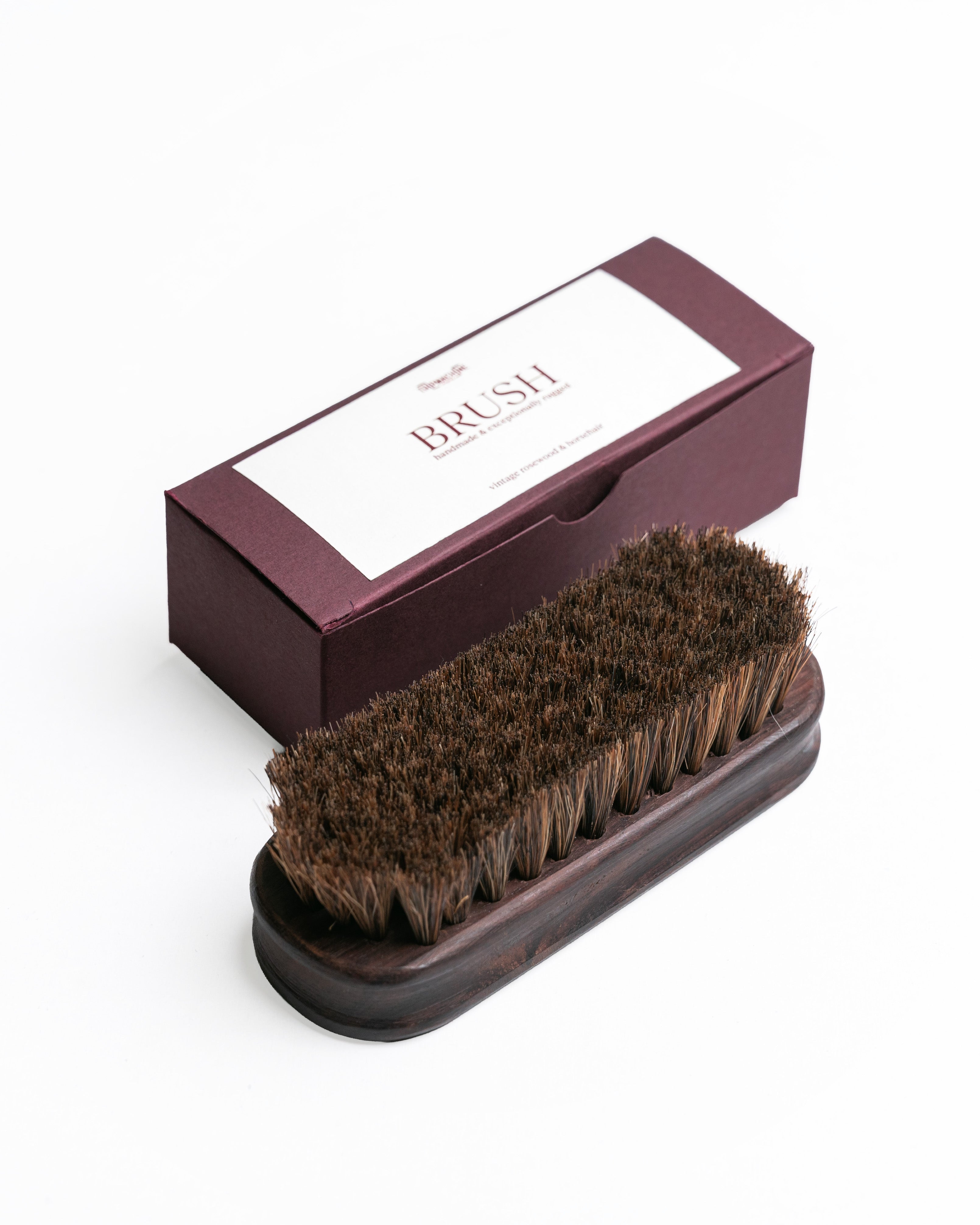 Brown brush with wooden handle in a matching box on a white background