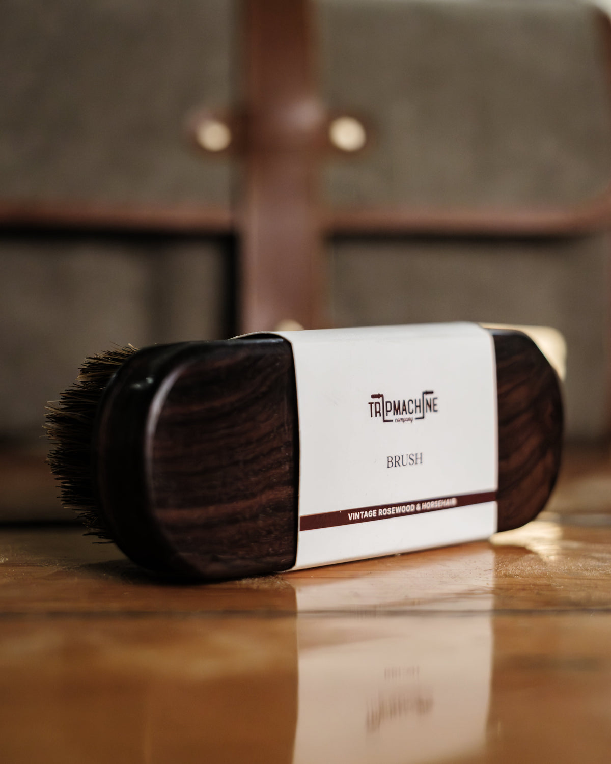 Cleaning brush with Tripmachine packaging on a wooden surface