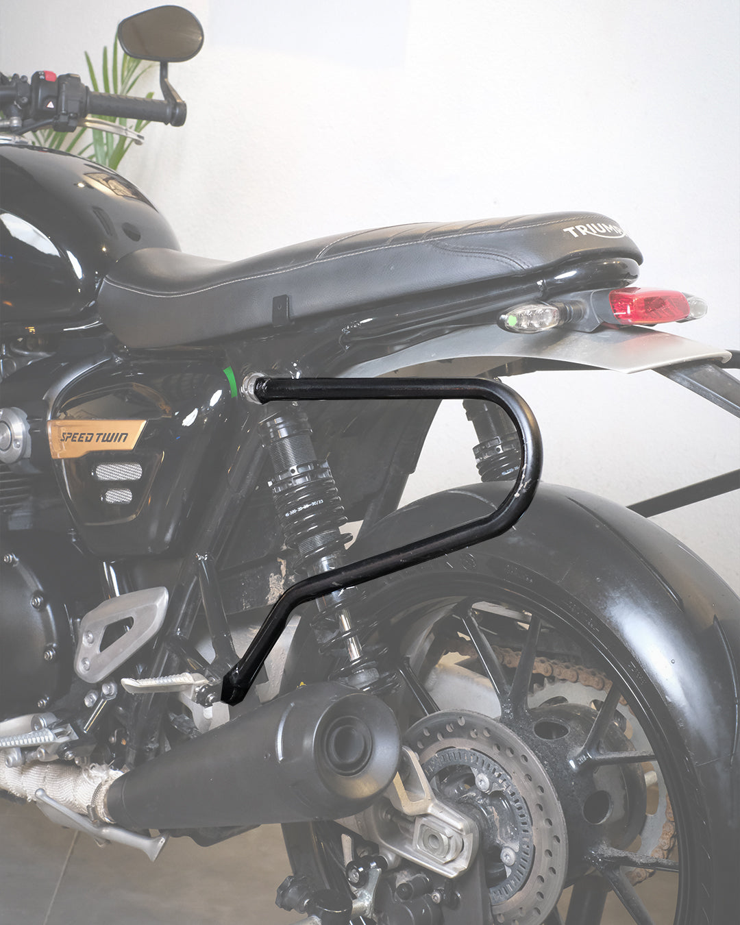 Black saddlestay on motorcycle with a visible brand logo on a white background