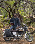 Man sitting on a motorcycle in a forest setting