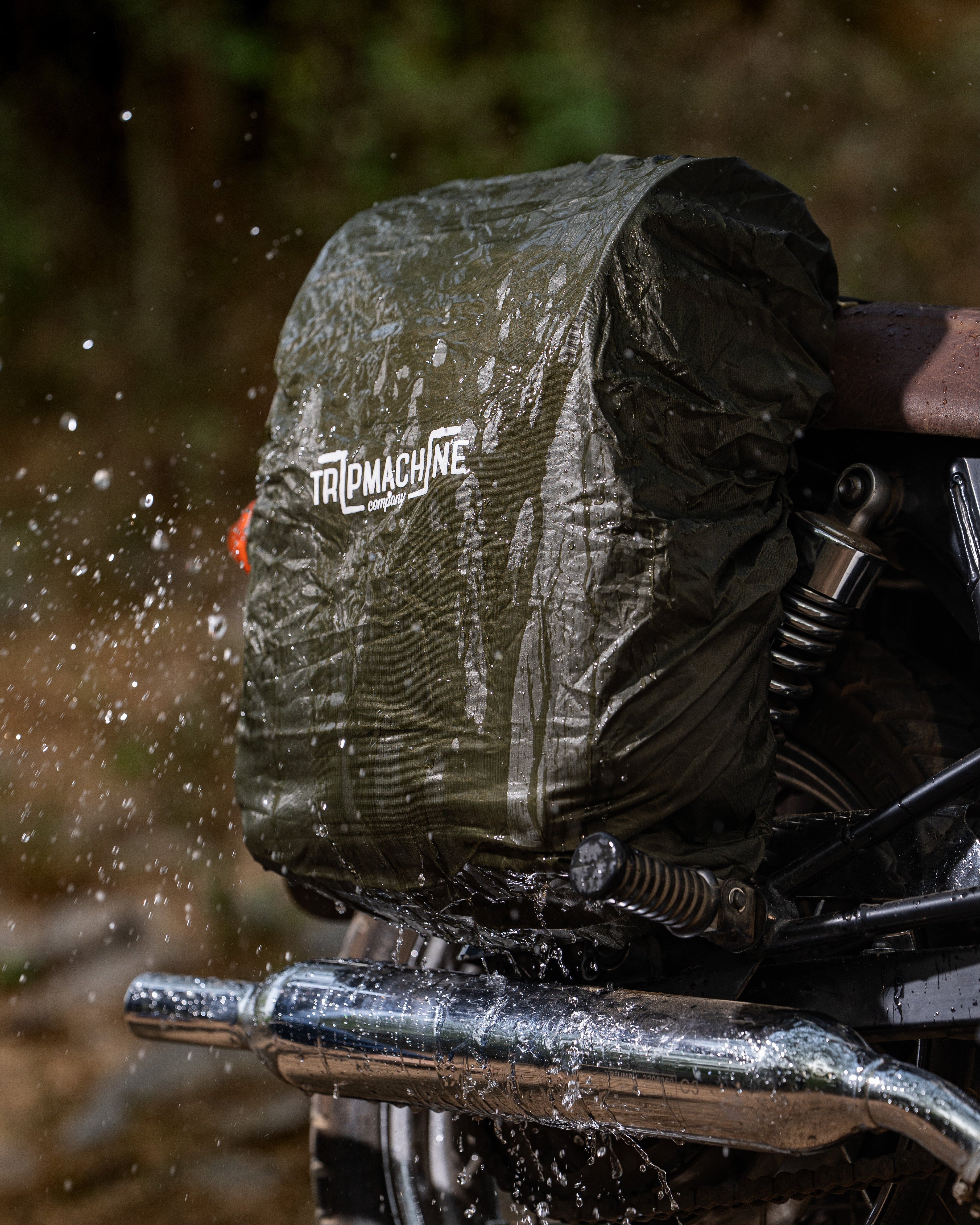 Motorcycle with a rain cover splashing through water, featuring the 'Frogtape' brand.