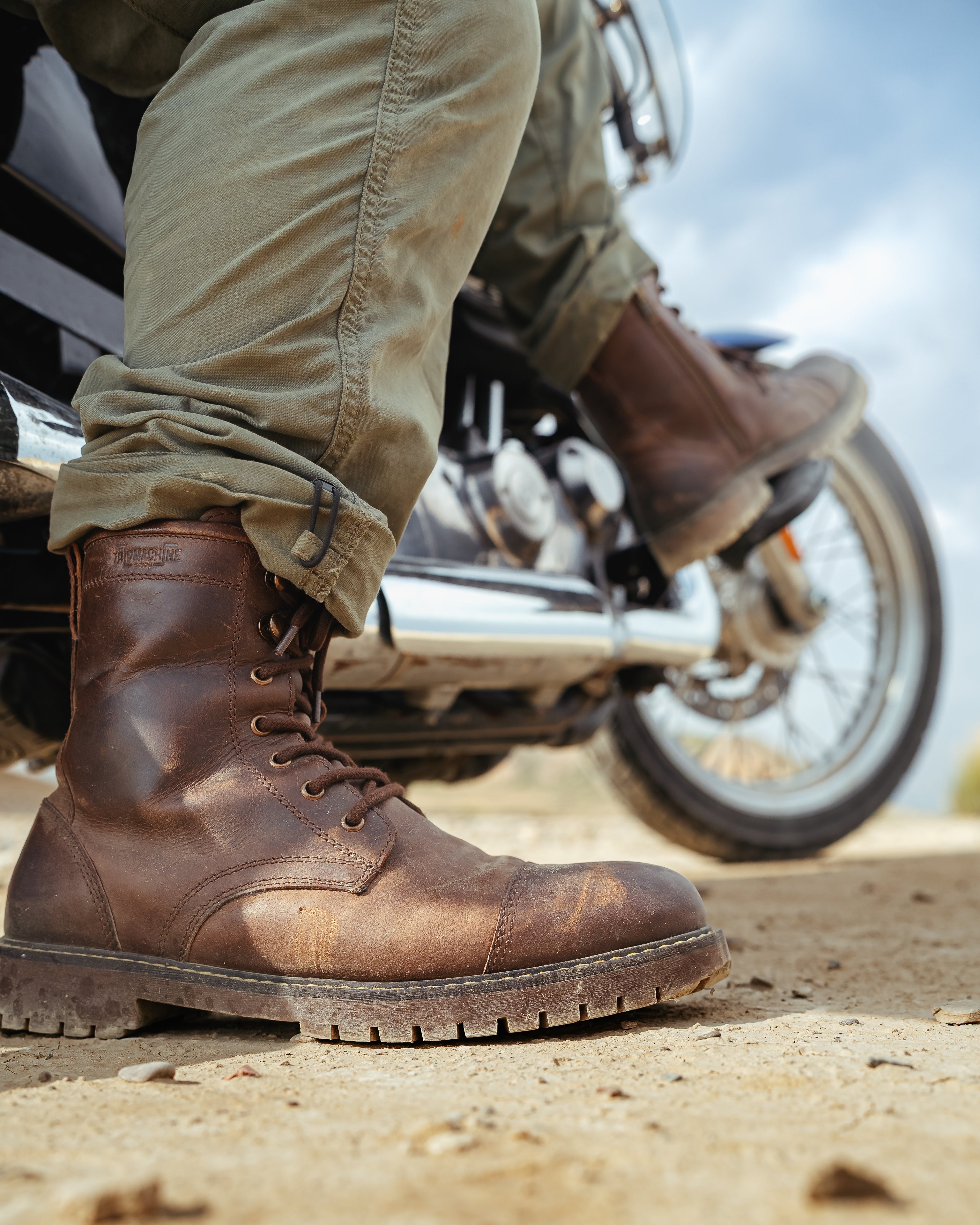 Brown leather boots on a motorcycle with a blurred background