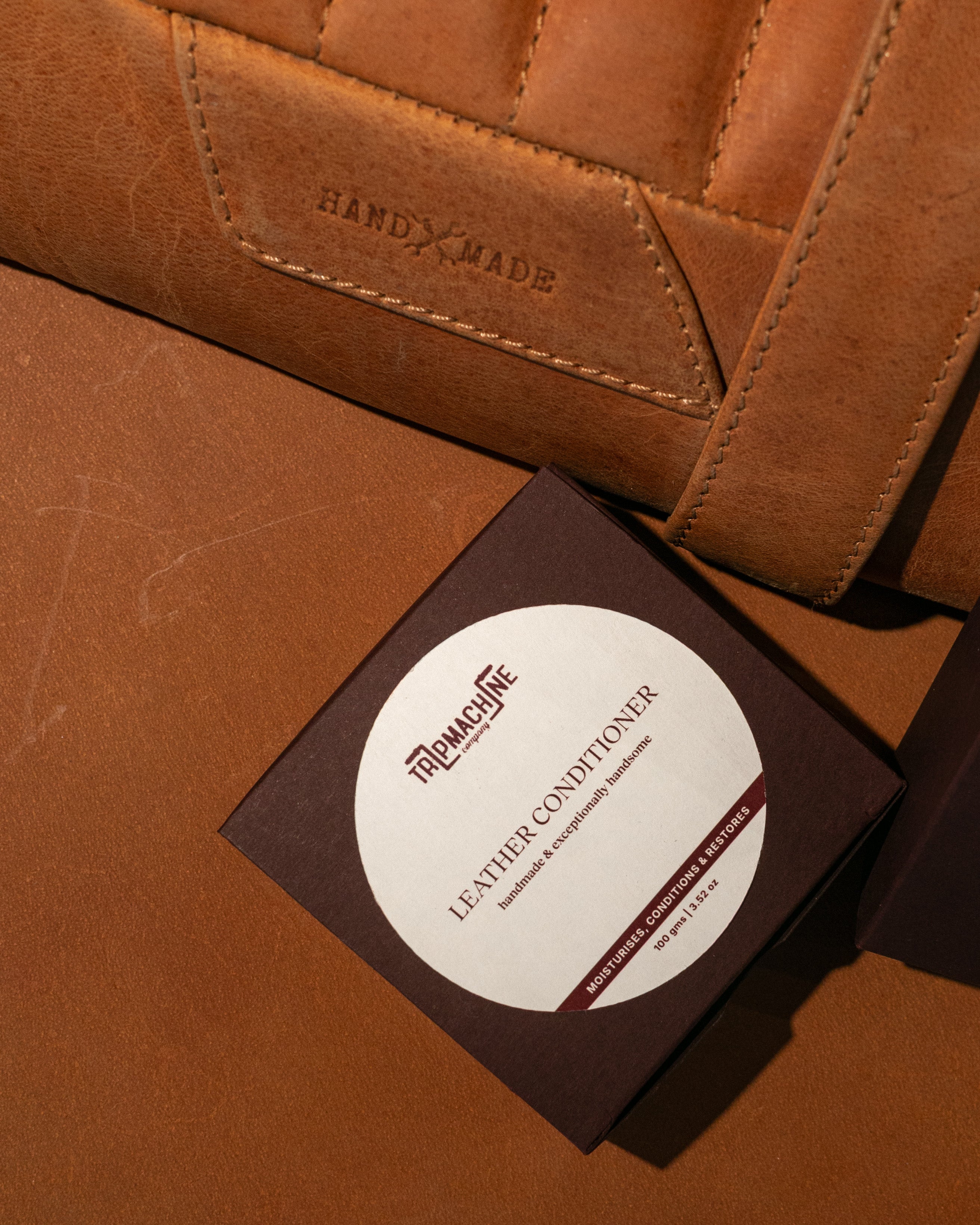 Brown leather product with a leather conditioner packaging on a matching brown background