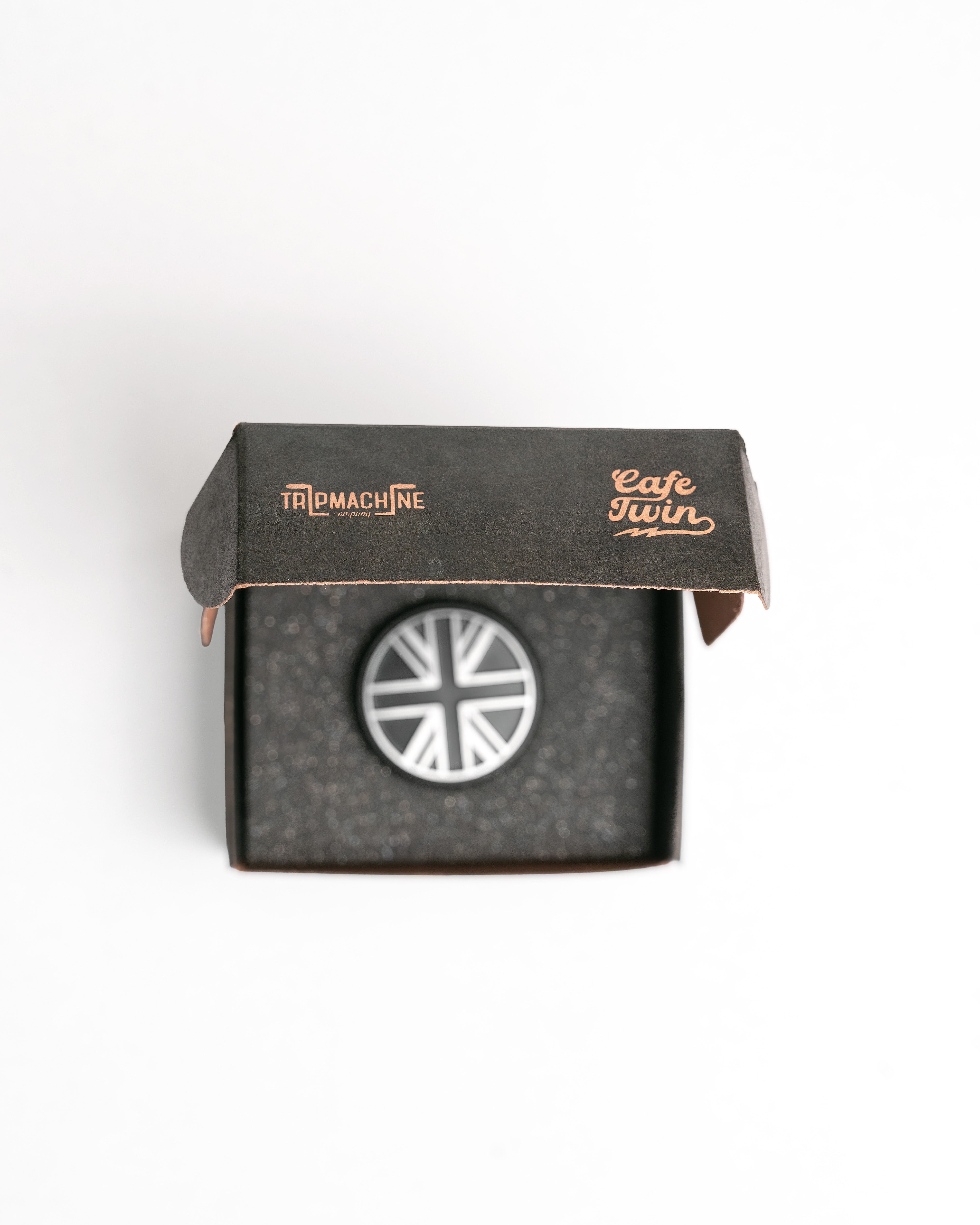 Oil filler cap in a black box with visible branding on a white background