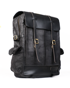 Black leather backpack with gold buckles on a white background